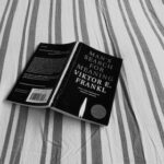 black book on gray and white striped textile