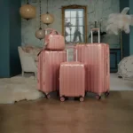 three pieces of pink luggage sitting in a room