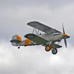white and orange bi-plane in mid air