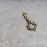 gold skeleton key on gray concrete floor