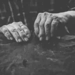 grayscale photo of persons hand with rings