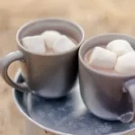 two mugs of beverages and marshmallows