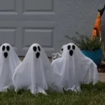 three ghost statues in front of a garage