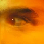 a close up of a man's eye with a blurry background