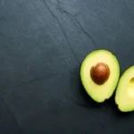 two green round fruits on gray textile