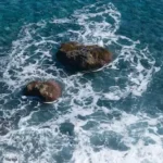 two rocks in the middle of a body of water