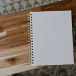 white spiral notebook on brown wooden table