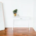 white wooden side table beside white wall