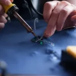 person using soldering iron