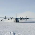 plane landing on snow field during daytime