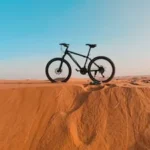 a bike is sitting on top of a sand dune