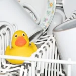 a yellow rubber duck sitting in a dishwasher
