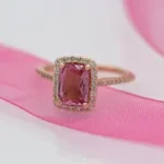 gold and silver ring on pink textile