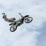 low angle photography of motocross player performing motocross flying style