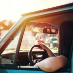 woman holding steering wheel sitting inside car