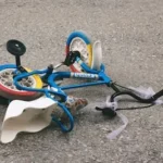 a broken toy bike laying on the ground