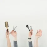 person holding silver and black hair brush