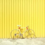 white and red hardtail bike on yellow wall