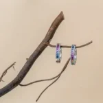 a pair of earrings hanging from a branch