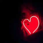 a heart shaped neon sign in the dark