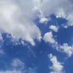 a plane is flying through the blue sky