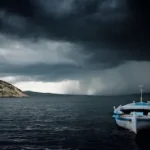black storm clouds over boats moored at beach