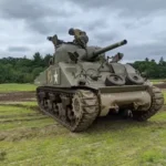 a military tank sitting on top of a lush green field