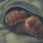 person holding babys foot