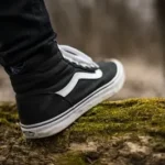 person wearing black and white Vans Sk8-Hi