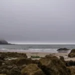 body of water near brown rock formation during daytime