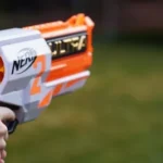 a close up of a person holding a toy gun