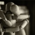 two wooden dummy hugging figures