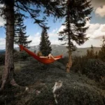 person lying on red hammock