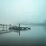 blue and white boat on dock during foggy weather