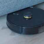 a black robot vacuum on a wooden floor