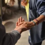 man and woman holding hands on street