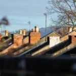 a row of chimneys on top of a brick building