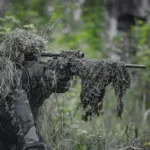sniper wearing a ghillie in selective focus photography