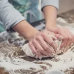 person standing and making dough