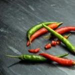 a group of red and green peppers on a table