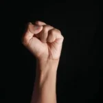 persons right hand doing fist gesture