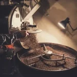 person pouring coffee beans on a machine