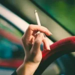 selective focus photography of single cigarette stick on person's hand