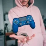 person holding blue Sony PS4 Dualshock 4 c