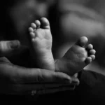 grayscale photo of babys feet